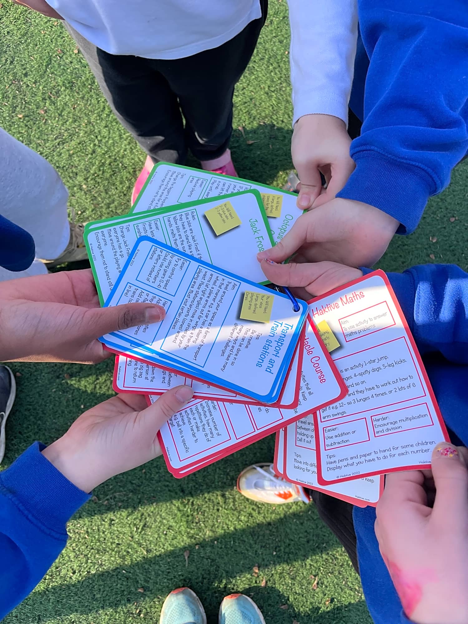 Children holding Haktive Cards on the school playground